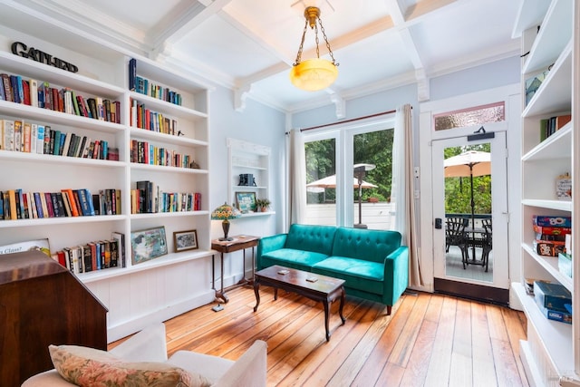 living area with beam ceiling, coffered ceiling, built in features, crown molding, and light hardwood / wood-style floors