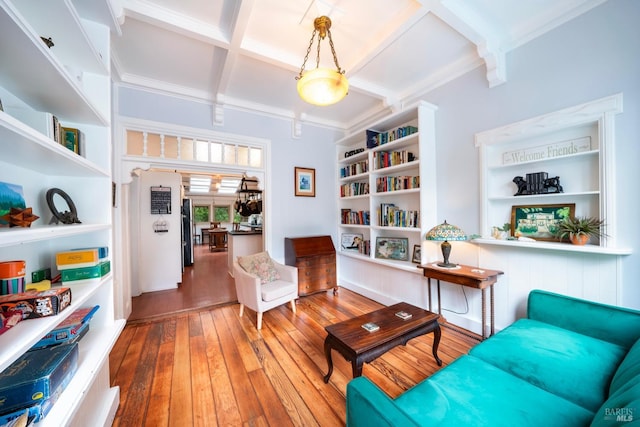 sitting room with ornamental molding, coffered ceiling, wood-type flooring, beam ceiling, and built in features