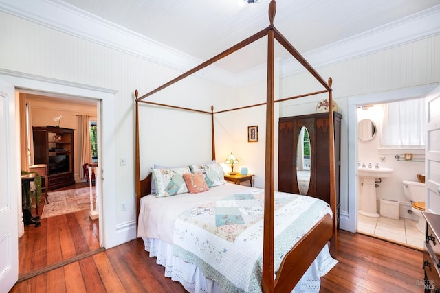 bedroom with dark hardwood / wood-style floors, sink, crown molding, and connected bathroom