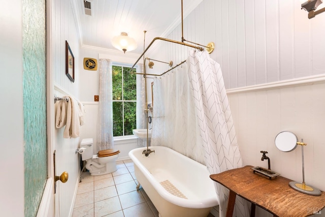 bathroom featuring crown molding, tile patterned flooring, a healthy amount of sunlight, and toilet