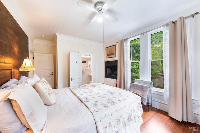 bedroom with ensuite bath, ceiling fan, hardwood / wood-style floors, and crown molding