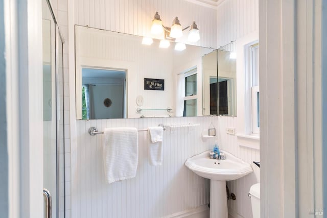 bathroom featuring sink, an enclosed shower, and toilet