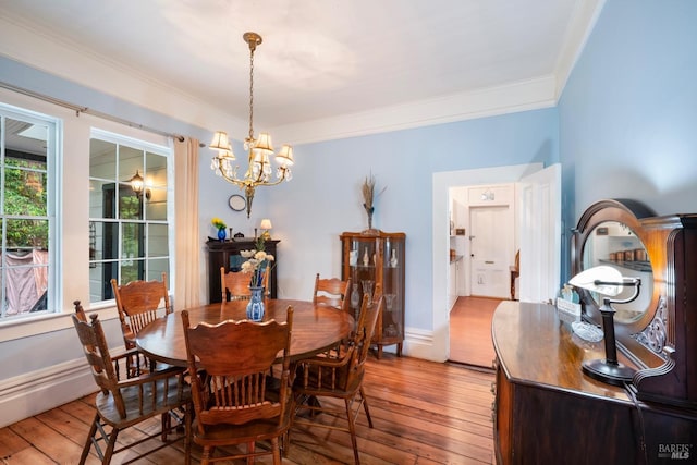 dining area with a chandelier, hardwood / wood-style floors, and crown molding