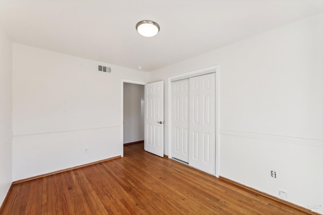 unfurnished bedroom with a closet and hardwood / wood-style flooring