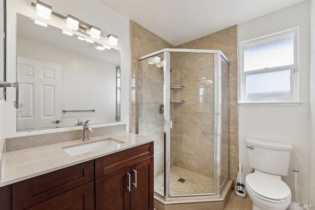 bathroom with toilet, vanity, and walk in shower