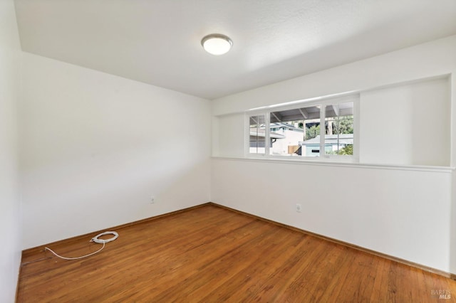 unfurnished room with hardwood / wood-style floors