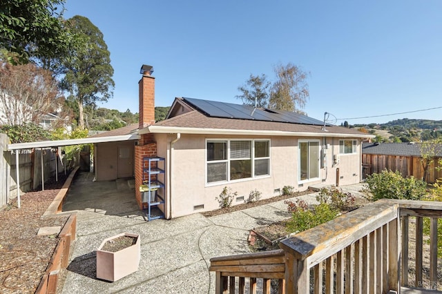 back of property featuring solar panels