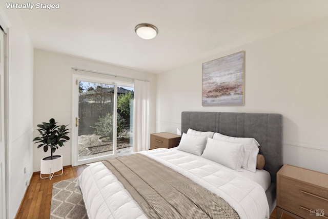 bedroom with access to exterior and dark wood-type flooring