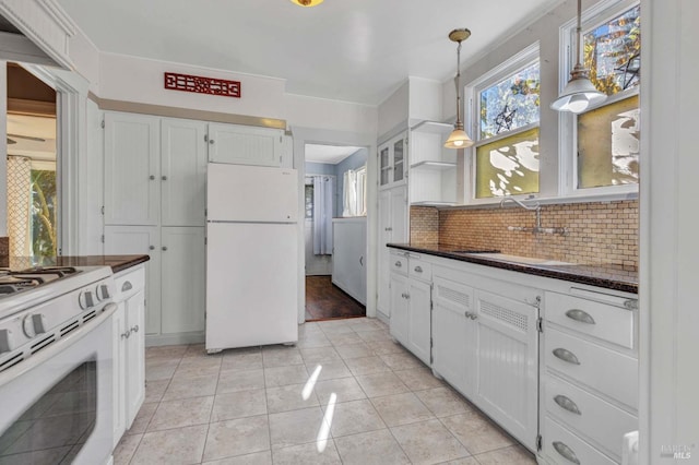 kitchen with tasteful backsplash, white appliances, hanging light fixtures, and white cabinets