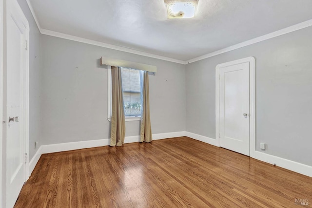 spare room featuring crown molding and wood-type flooring