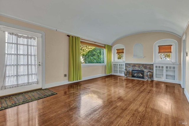 unfurnished living room featuring hardwood / wood-style flooring, a fireplace, and vaulted ceiling