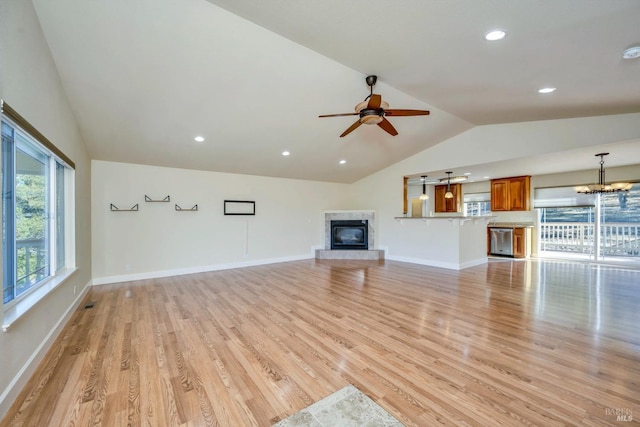 19316 N Shore Ct, Hidden Valley Lake, CA 95467 - unfurnished living room featuring lofted ceiling, a premium fireplace, baseboards, light wood-style flooring, and ceiling fan with notable chandelier