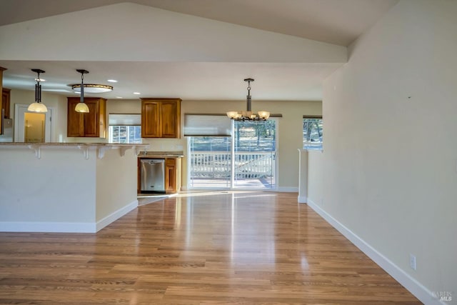 kitchen with dishwasher, a chandelier, light hardwood / wood-style floors, lofted ceiling, and a breakfast bar area