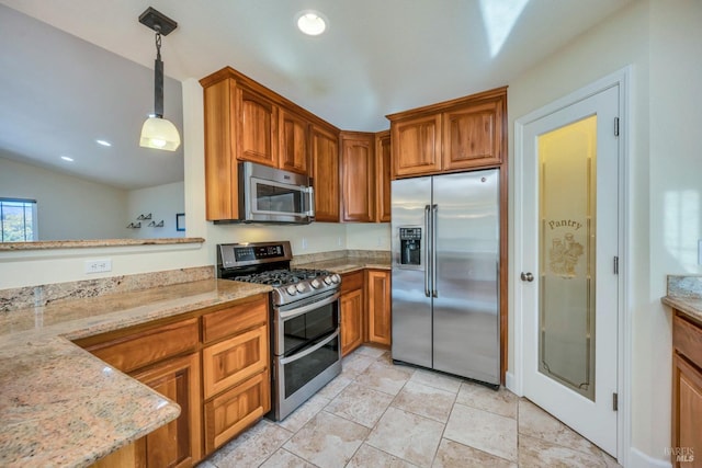 kitchen featuring light stone countertops, appliances with stainless steel finishes, and pendant lighting