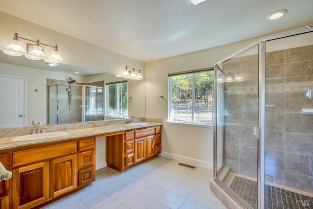 bathroom featuring a shower with door, vanity, and tile patterned flooring