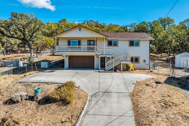19316 N Shore Ct, Hidden Valley Lake, CA 95467 - view of front of house featuring a storage unit, covered porch, concrete driveway, a garage, and stairway