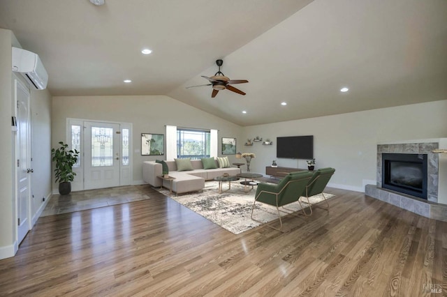 living room with an AC wall unit, ceiling fan, lofted ceiling, and light wood-type flooring