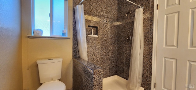 bathroom featuring a shower with shower curtain and toilet