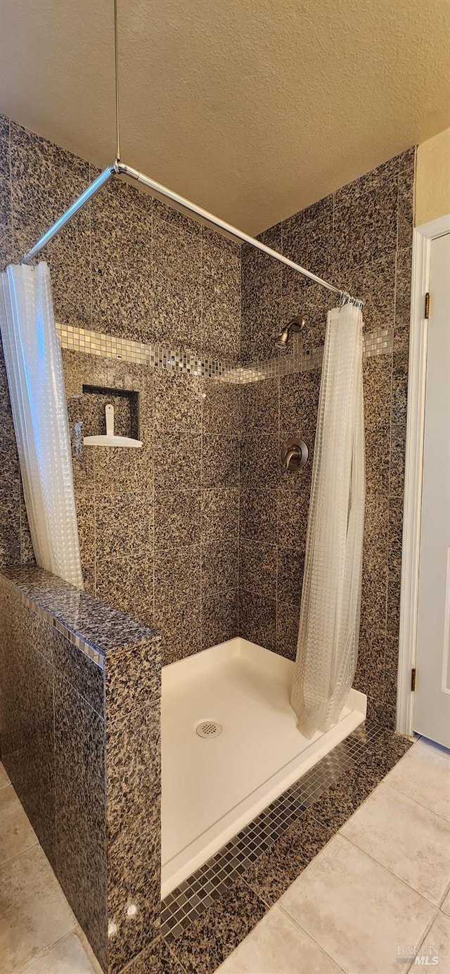 bathroom featuring a shower with shower curtain and a textured ceiling