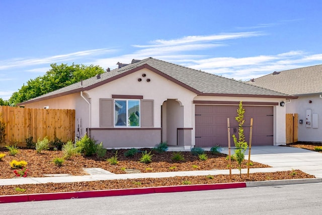 view of front facade with stucco siding, fence, concrete driveway, a shingled roof, and a garage