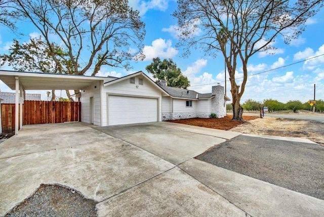 view of home's exterior featuring concrete driveway, fence, a chimney, and an attached garage