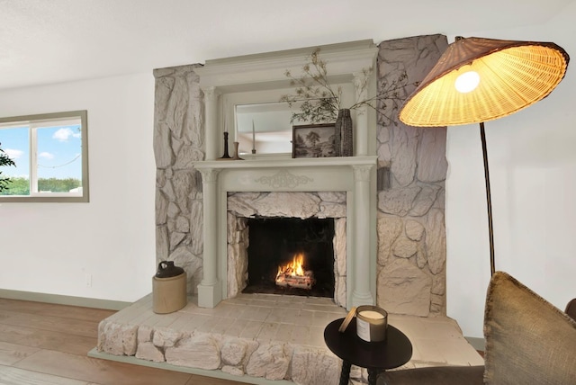 interior details with a fireplace, wood finished floors, and baseboards