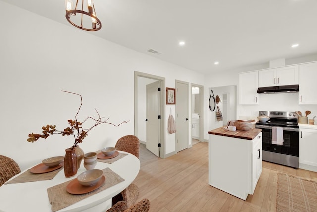 kitchen with visible vents, light wood-style flooring, butcher block countertops, stainless steel electric range, and under cabinet range hood