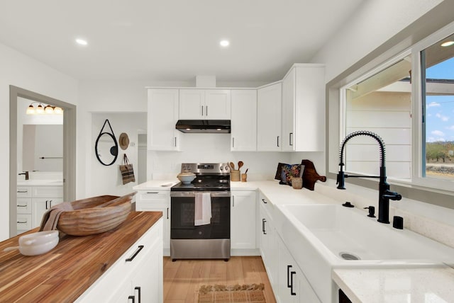 kitchen featuring electric range, white cabinets, light wood-type flooring, and sink