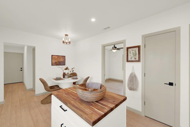 kitchen featuring visible vents, wooden counters, light wood-style flooring, an inviting chandelier, and white cabinetry