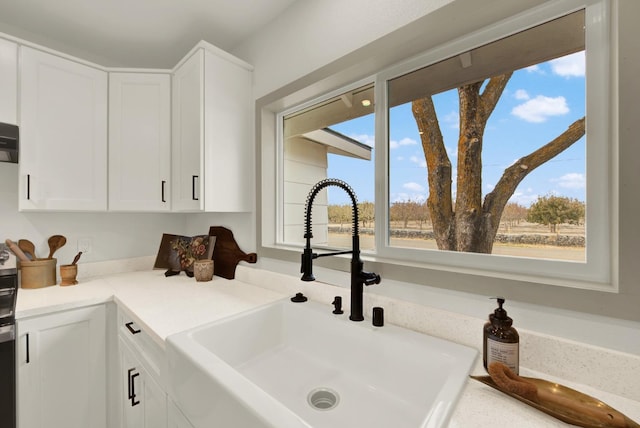 room details featuring light countertops, a sink, and white cabinetry