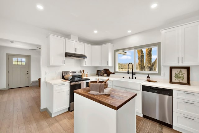 kitchen featuring recessed lighting, wooden counters, appliances with stainless steel finishes, a sink, and under cabinet range hood