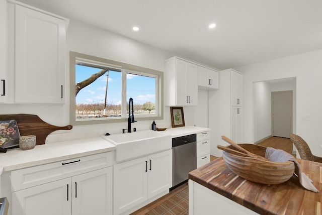 kitchen featuring recessed lighting, a sink, white cabinetry, wooden counters, and stainless steel dishwasher