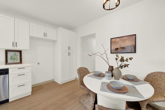 dining space with baseboards and light wood-style floors