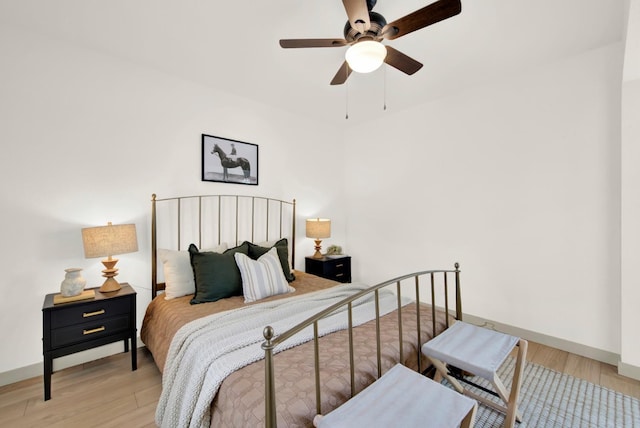 bedroom with a ceiling fan, baseboards, and wood finished floors