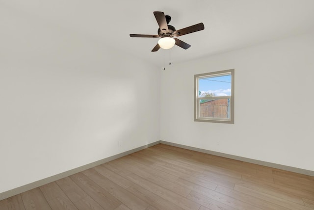 unfurnished room with ceiling fan, light wood finished floors, and baseboards