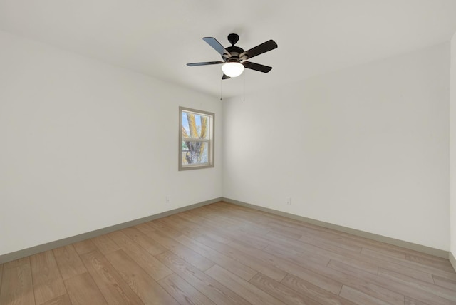 spare room with light wood finished floors, baseboards, and a ceiling fan