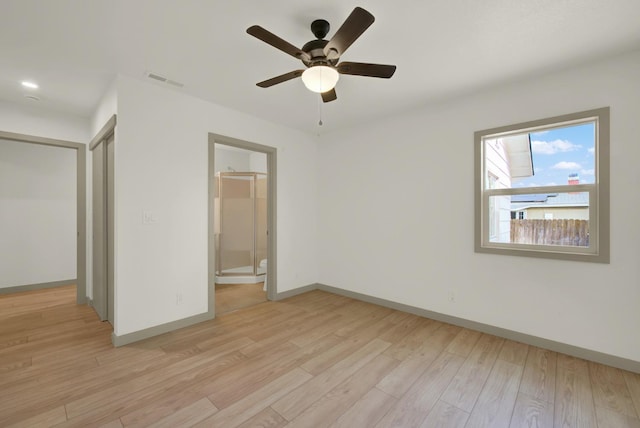 unfurnished bedroom with ceiling fan, connected bathroom, visible vents, baseboards, and light wood finished floors