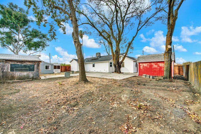 exterior space featuring a patio area, a fenced backyard, a storage shed, and an outdoor structure