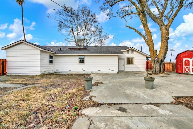 exterior space with a storage shed, fence, an outbuilding, and a patio