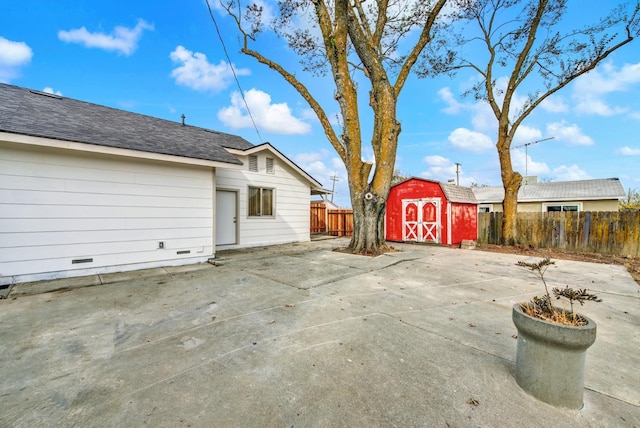 exterior space featuring an outdoor structure, fence, and a storage shed