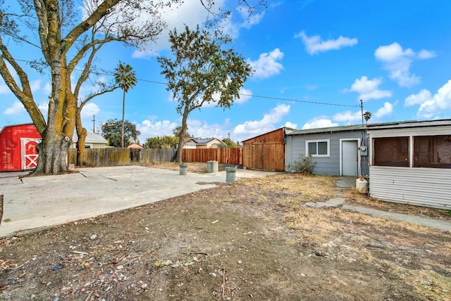 view of yard featuring fence, an outdoor structure, and a storage shed