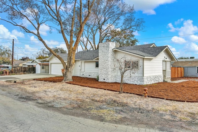 view of front of home with a garage, a shingled roof, fence, driveway, and a chimney