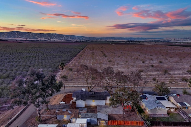 aerial view at dusk with a rural view and a mountain view