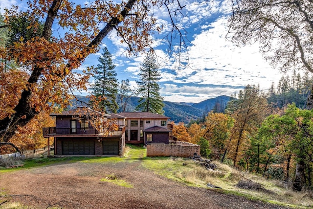 view of front of home featuring a deck with mountain view and a garage