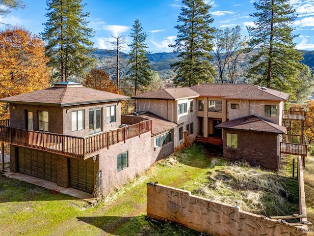 back of house with a mountain view and a garage