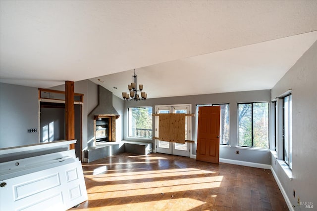 interior space featuring dark hardwood / wood-style flooring, lofted ceiling, and an inviting chandelier