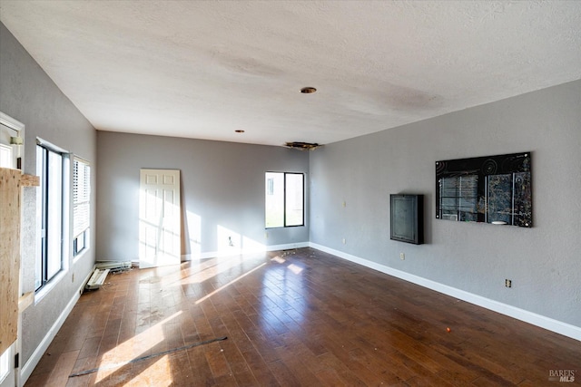 spare room with dark hardwood / wood-style flooring and a textured ceiling