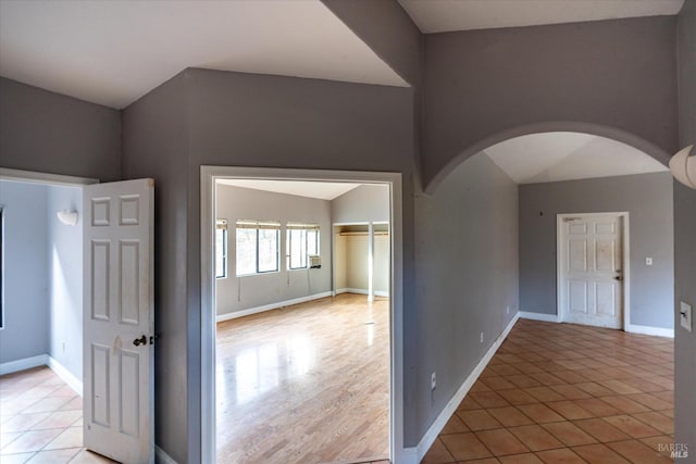 unfurnished room featuring vaulted ceiling and light hardwood / wood-style flooring