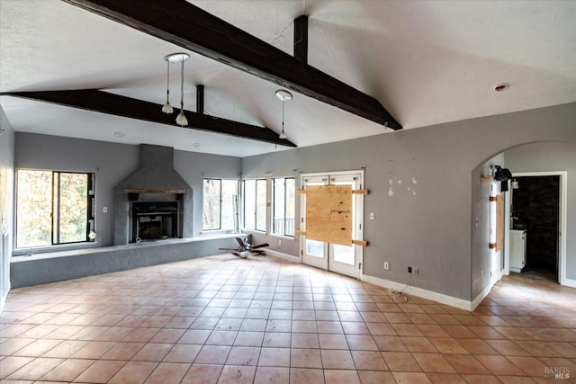 unfurnished living room with lofted ceiling with beams, ceiling fan, light tile patterned floors, and a fireplace