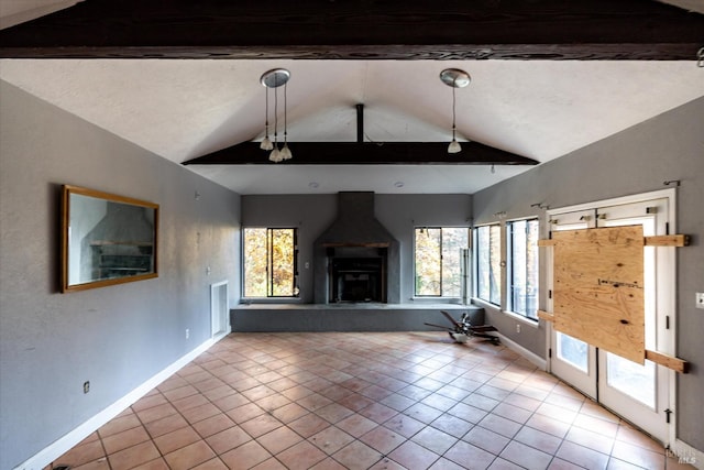 unfurnished living room featuring vaulted ceiling with beams, a wealth of natural light, a fireplace, and light tile patterned floors